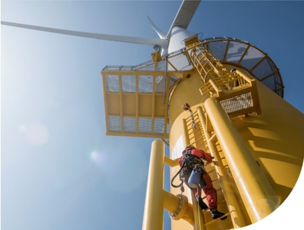 A person climbing a wind turbine.