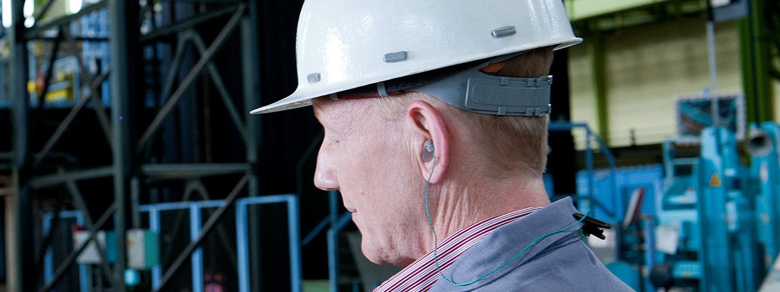 A worker wearing a protective helmet and earplugs.