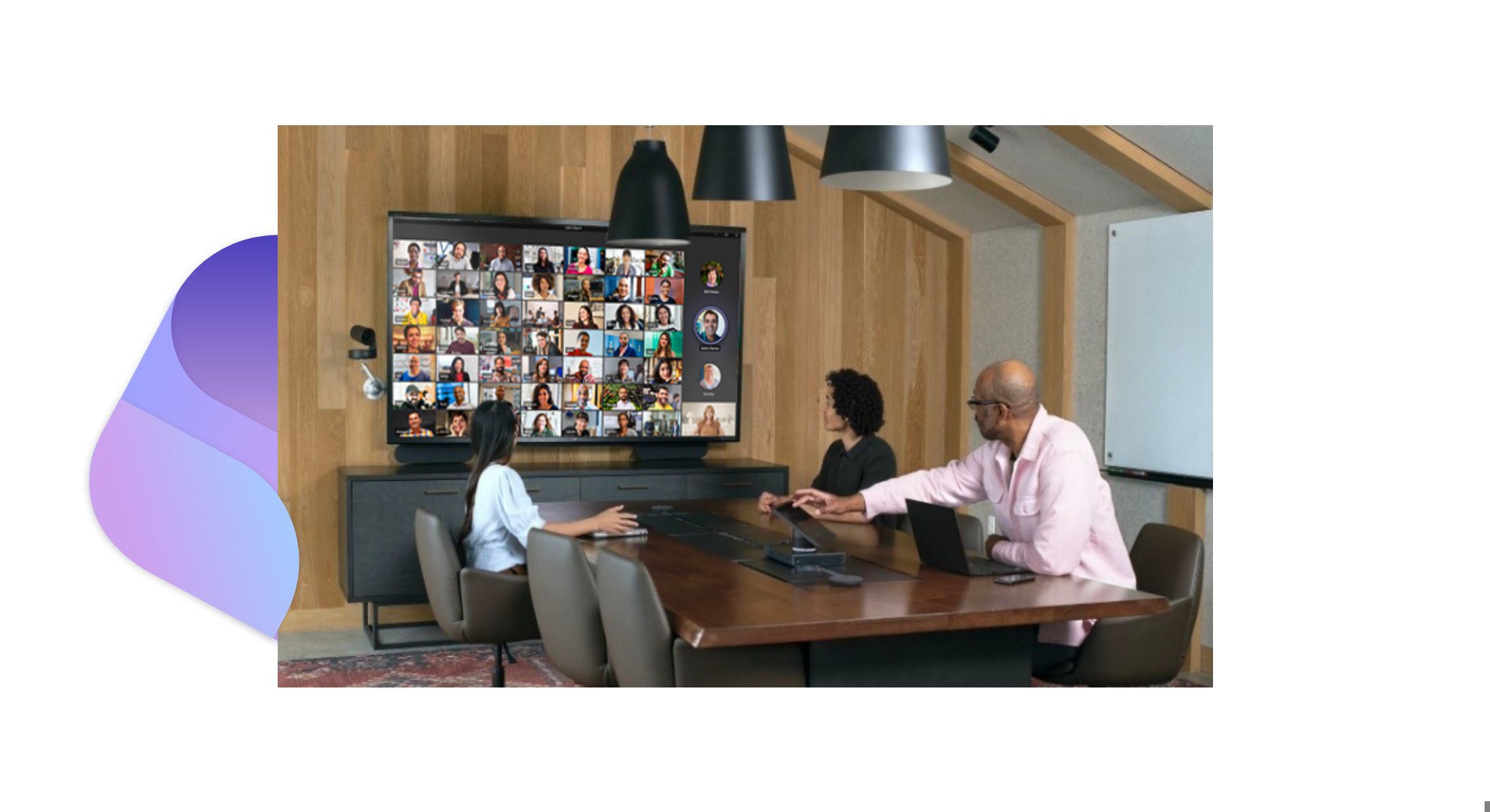 Three people in a conference room participating in a Teams video call with many participants.