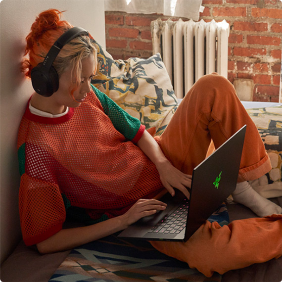 Meisje met hoofdtelefoon op werkt op haar laptop
