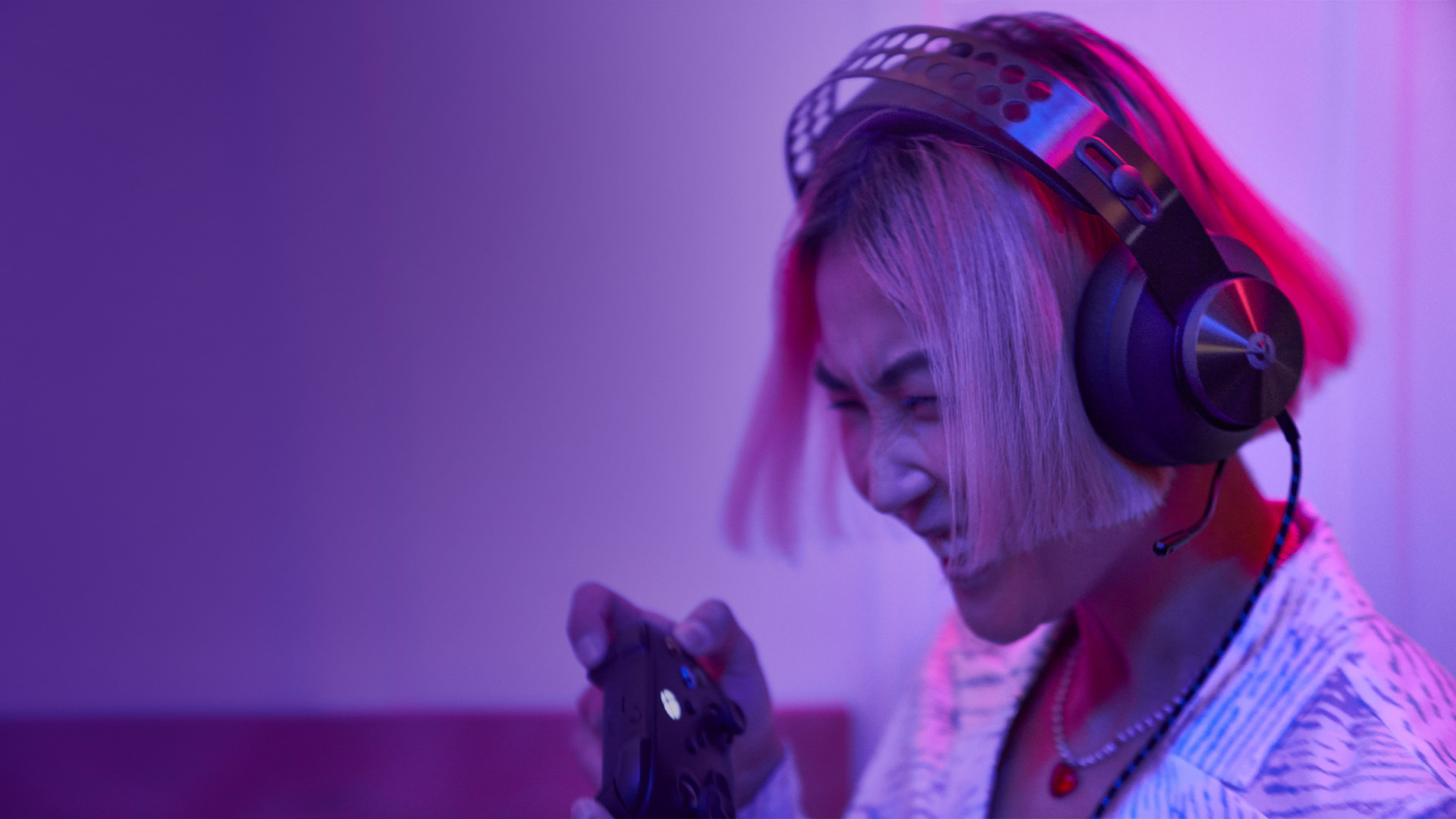 Woman wearing headphones and holding a gaming controller