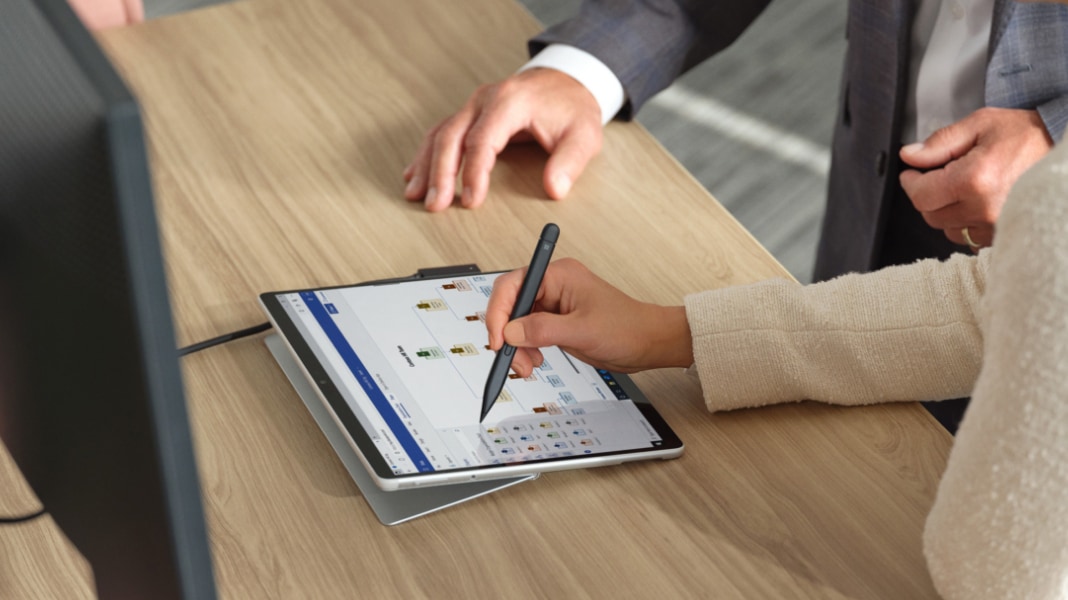 A person exploring an organizational chart on a tablet with a pen.