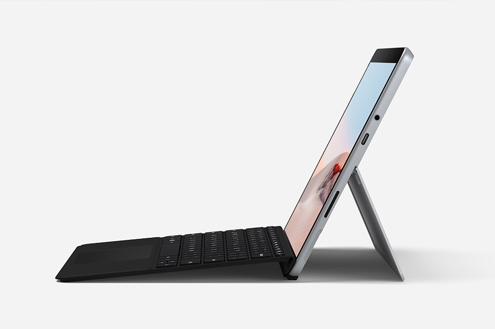 Twee mensen zitten aan tafel en werken met Surface Go 2 voor zakelijk gebruik-tablet