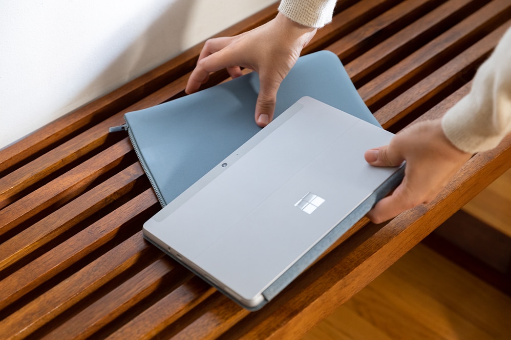 Person holding Surface Go Sleeve (sleeve name) and Surface Go Sleeve (device name)