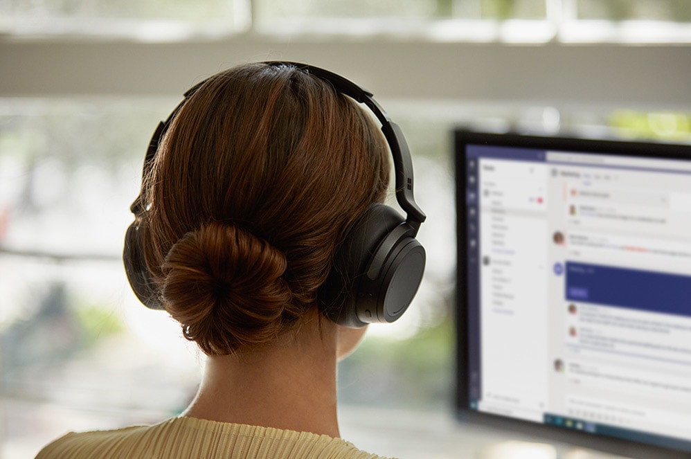 A woman talks with Surface headphone 2 on
