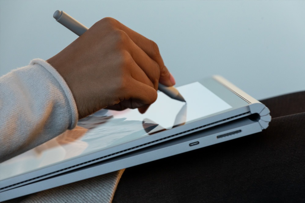 A person sketches with Surface Pen on their Surface Book 3 in studio mode