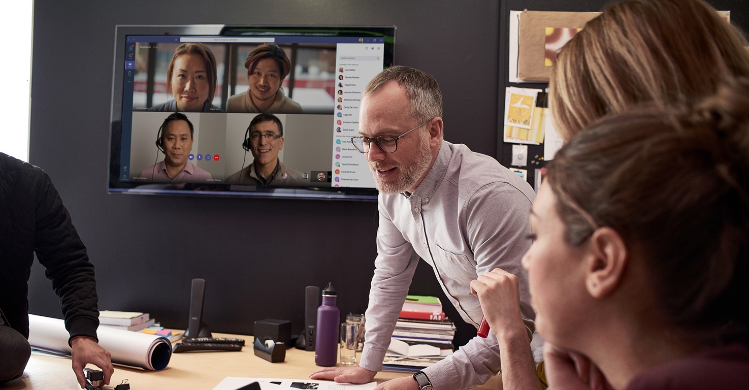 People participating in a meeting in person and online with Microsoft Teams