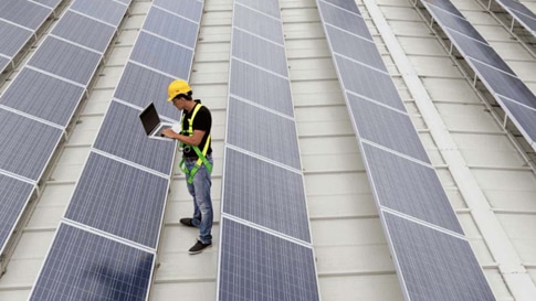 Worker inspecting solar panels 