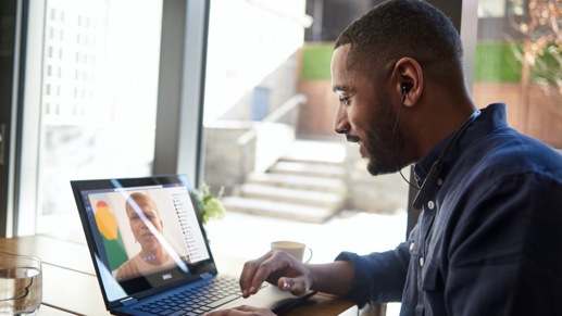 Person seated and looking at a Microsoft Surface in laptop mode