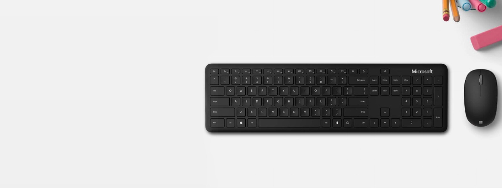 Microsoft Bluetooth Keyboard е поставена до Microsoft Bluetooth Mouse на бюро с писалка, маркер и гума
