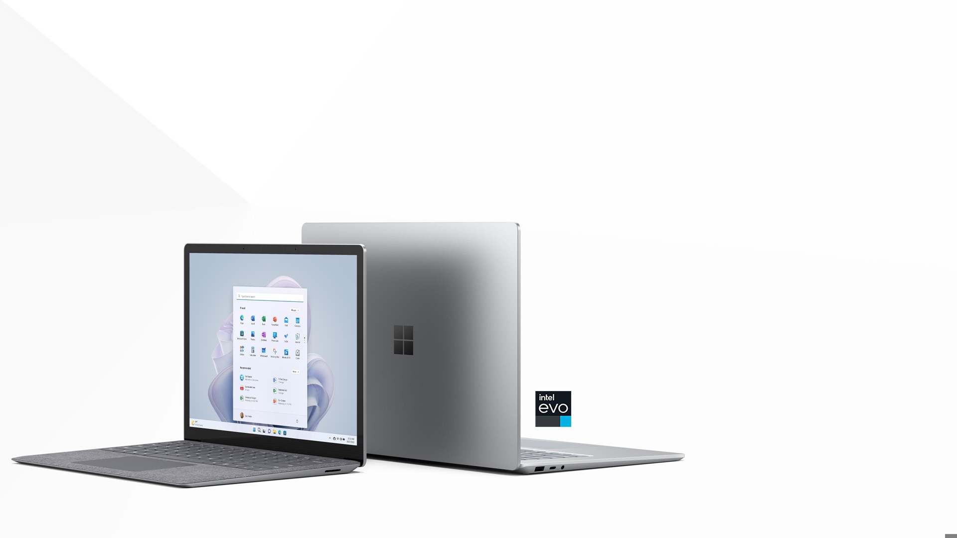 De twee formaten van de Surface Laptop 5, naast elkaar afgebeeld. De versie van 13,5 inch in de kleur platina staat vooraan, volledig geopend en met het startscherm erop weergegeven.