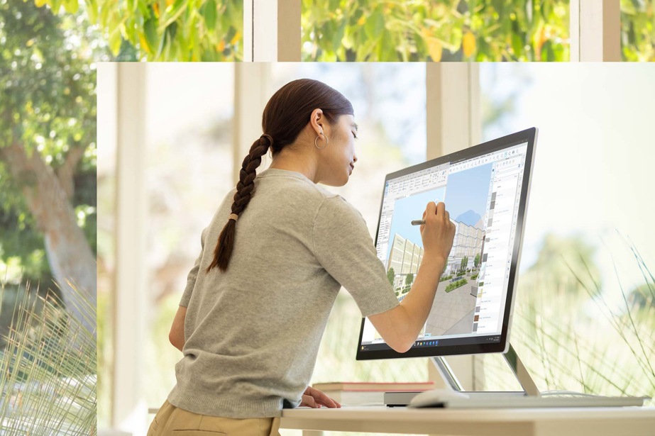 Eine Person steht vor ihrem Surface Studio 2+ und zeichnet mit dem Surface Pen auf dem Bildschirm, um ein Design zu erstellen.