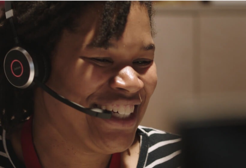 A person wearing a headset smiling.
