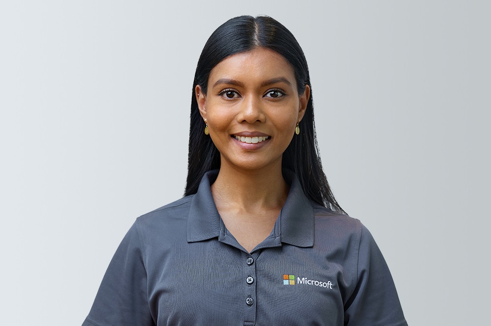 Shefa, a Microsoft business product expert, smiles while wearing a shirt with a Microsoft logo.