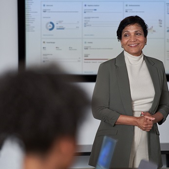 Woman standing in front of a small group doing a presentation in a conference room.