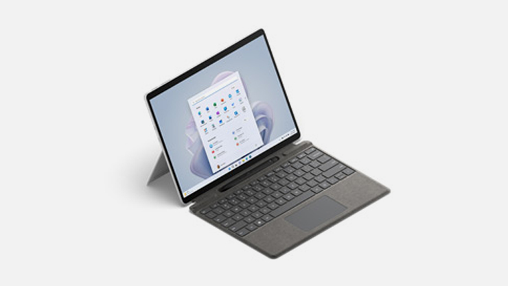 A 3/4 view from above of Surface Pro 9 in Platinum with a Surface Type Cover attached.