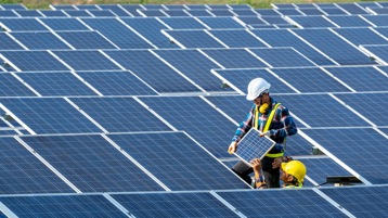 Two workers installing solar panels.
