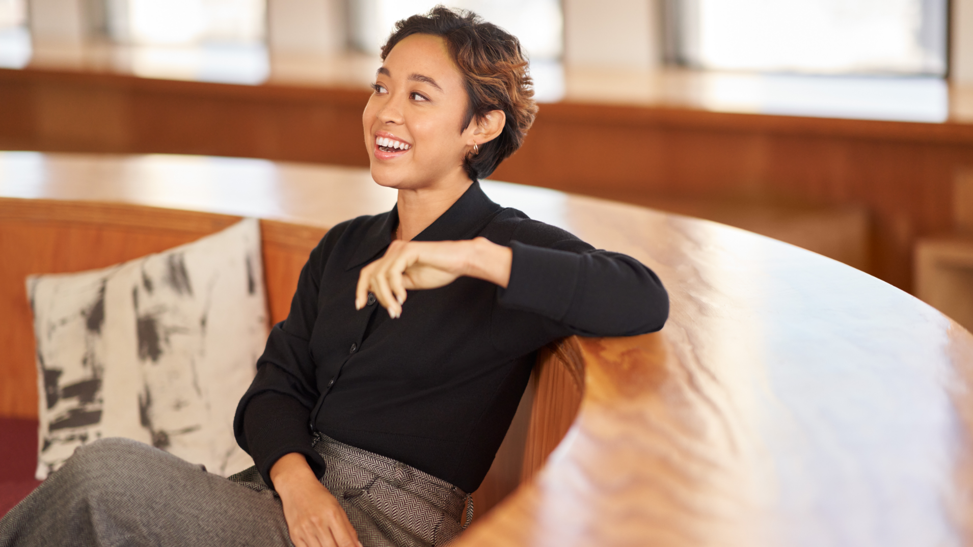 A person sitting in a rounded chair smiling.