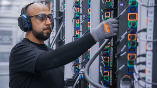 A Microsoft employee plugs in a power cord in a Microsoft Azure datacenter. 
