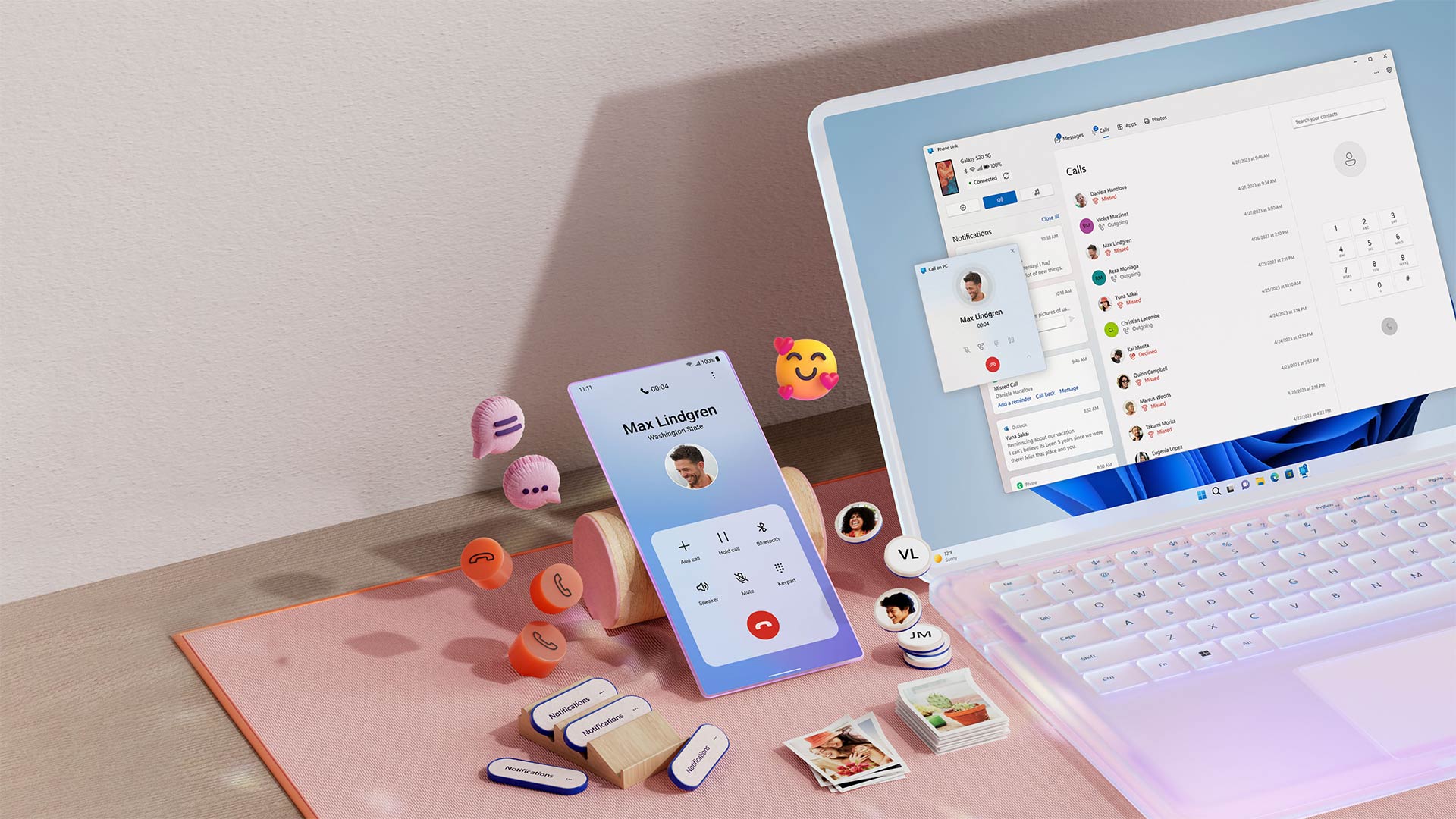 Notebook aberto ao lado de um celular com emojis flutuantes