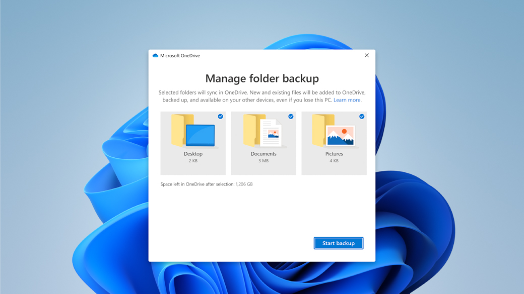 La flor de Windows en el fondo con el cuadro de diálogo de Microsoft OneDrive para administrar la copia de seguridad de las carpetas