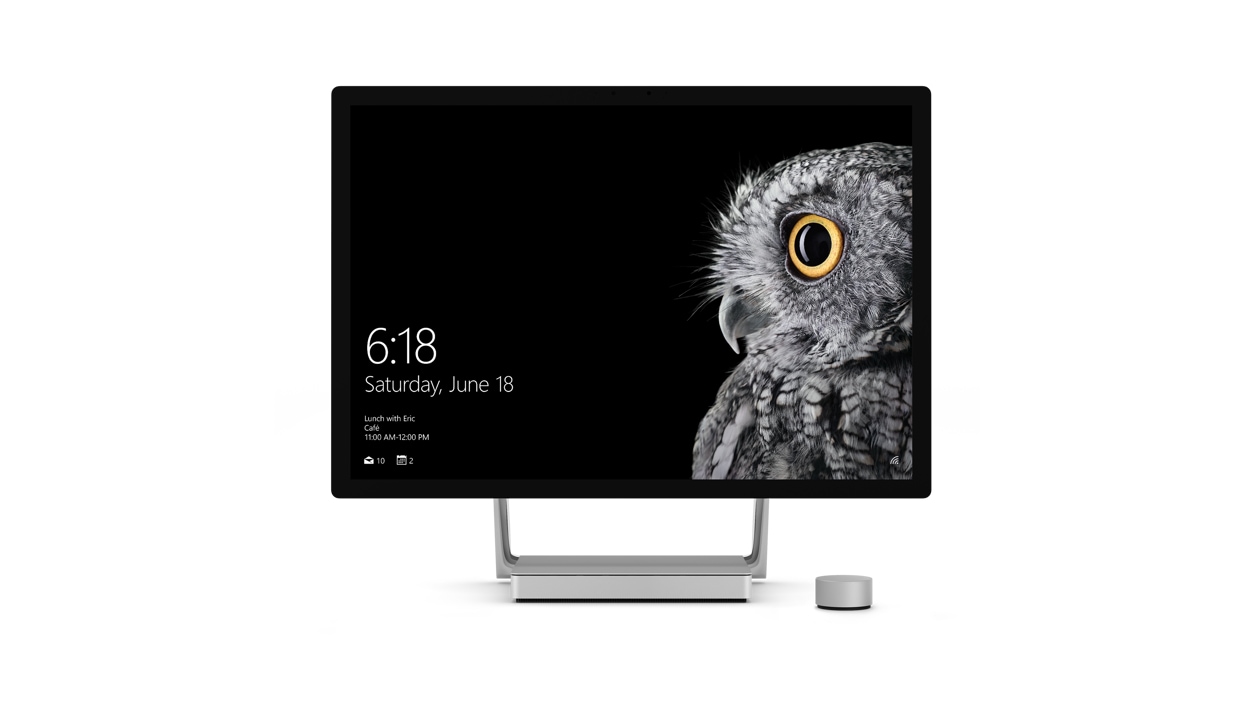 前向きの Surface Studio の隣に置かれている Surface Dial