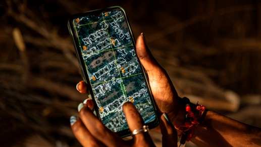 Hands holding a smartphone with an image of a map on the screen.