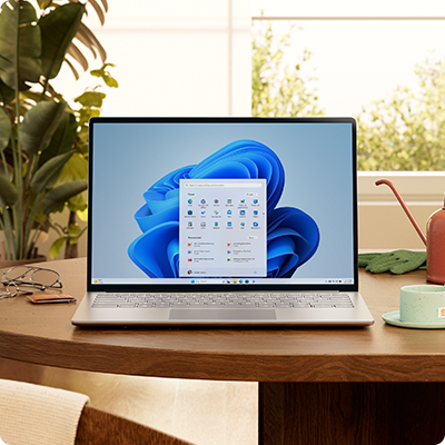 Windows 11-pc med menuen Start og en blå blomst