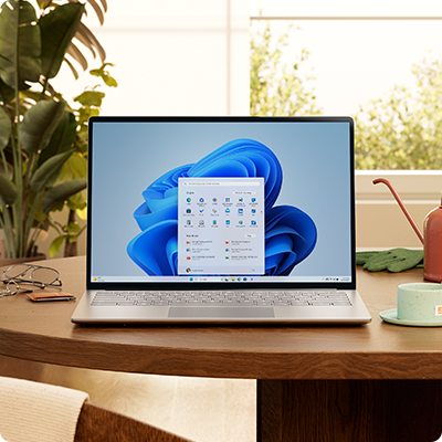 PC chạy Windows 11 với menu Bắt đầu và bông hoa nở màu xanh lam