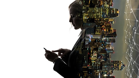 A person using a mobile phone and a city skyline.