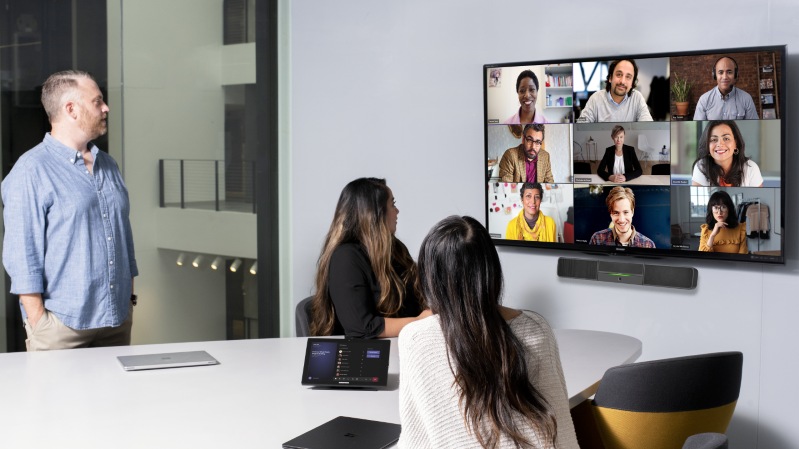 Ein Mann und zwei Frauen halten ein virtuelles Teams Meeting.