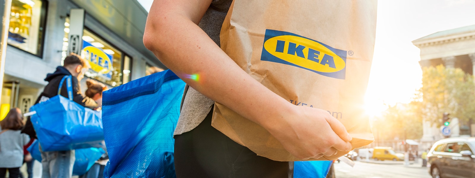 Mensch mit Ikea Papiertüte auf dem Arm.
