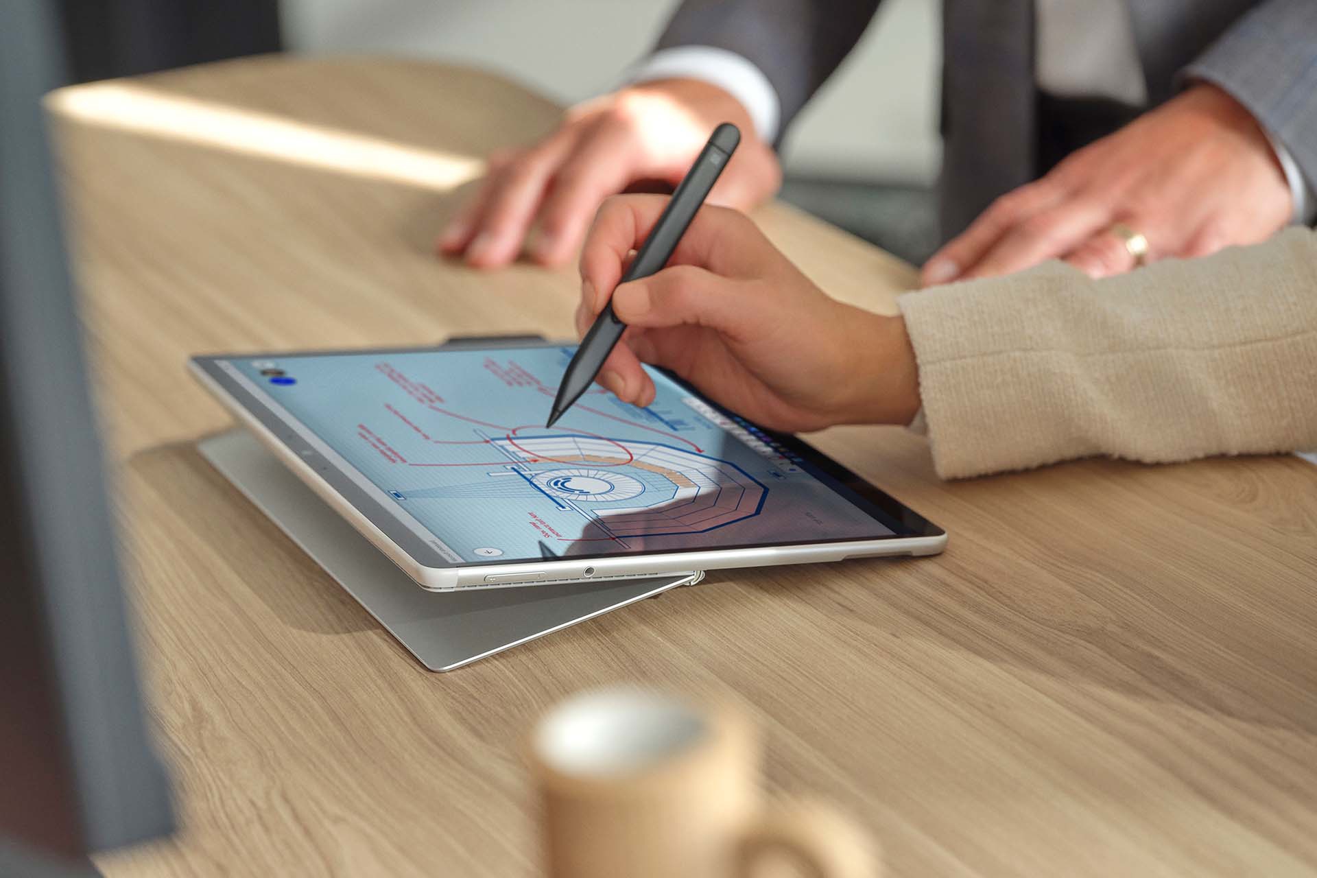 A person's hand is observed using Surface Slim Pen 2 on the screen of Surface Pro 8