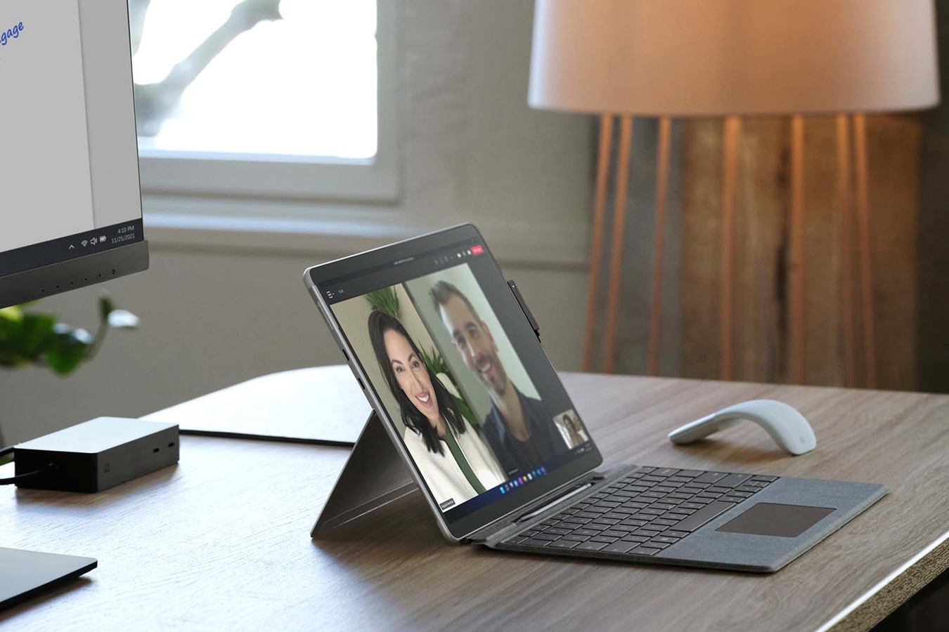 Surface Pro X na stole v kancelářském prostředí vedle myši Surface Arc