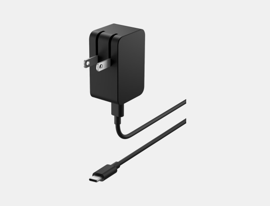 Side angle view of Surface 23W USB-C Power Supply showing power plug and USB-C plug.