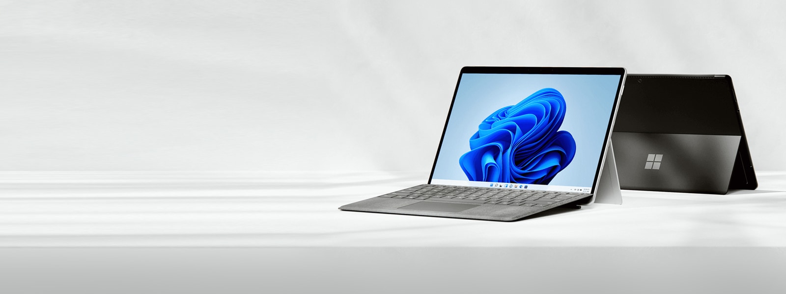 背面と前面図を示す、2 台の開いた Surface Pro 8 デバイス。