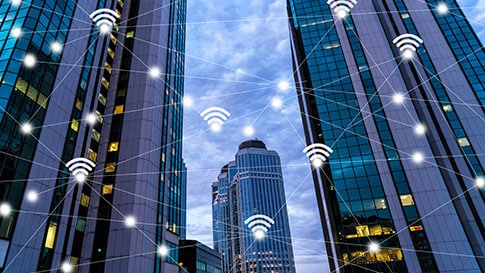 Stadsgebouwen verbonden door wifi-symbolen.