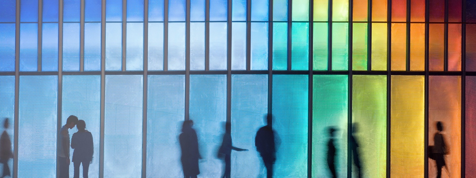 Personas frente a una fachada colorida iluminada con ledes
