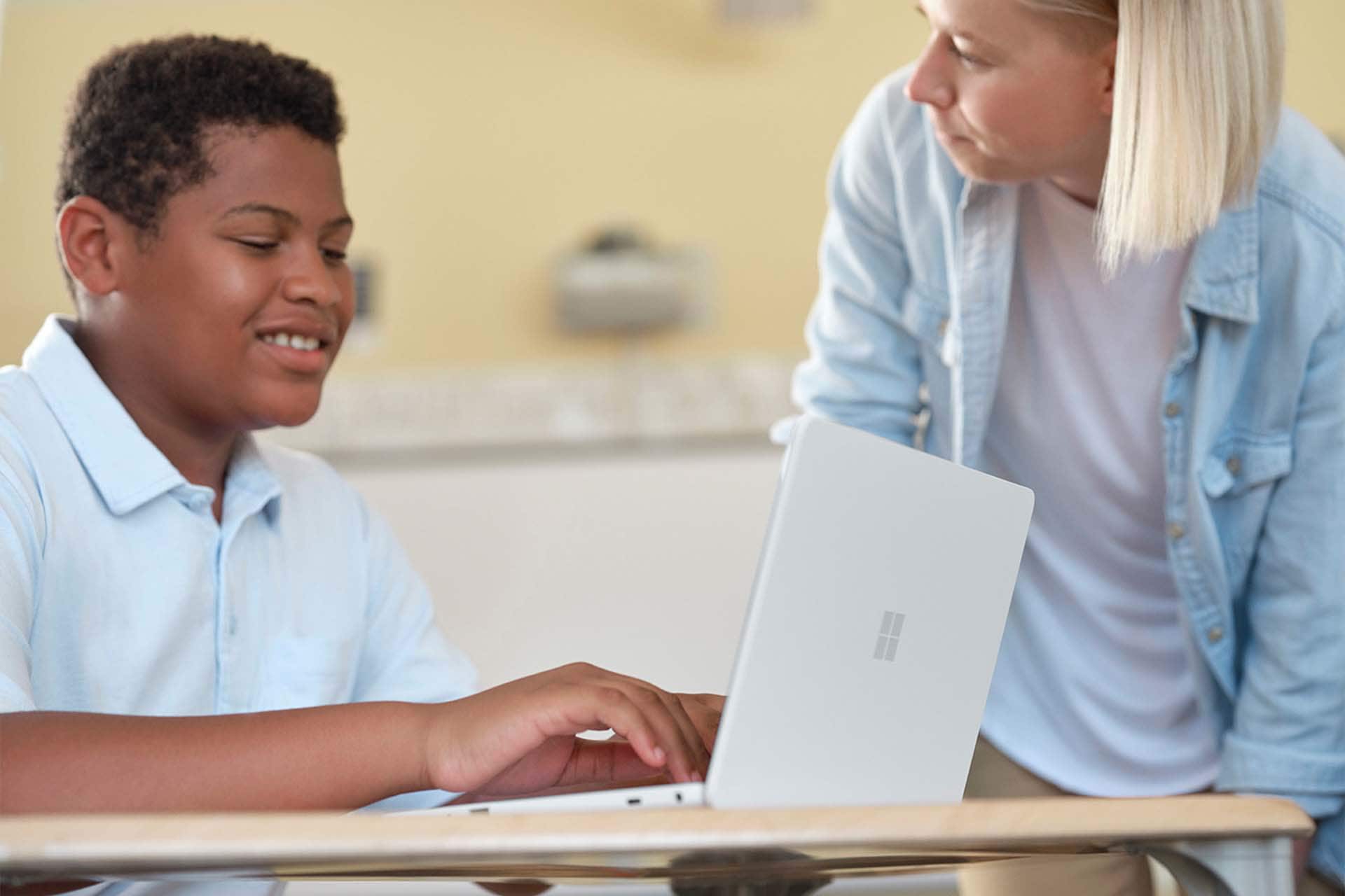 Student using a Surface Laptop SE asks a Teacher a question