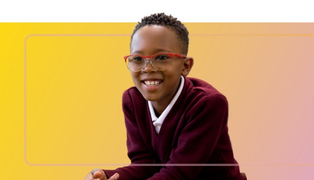 A smiling child wearing glasses.