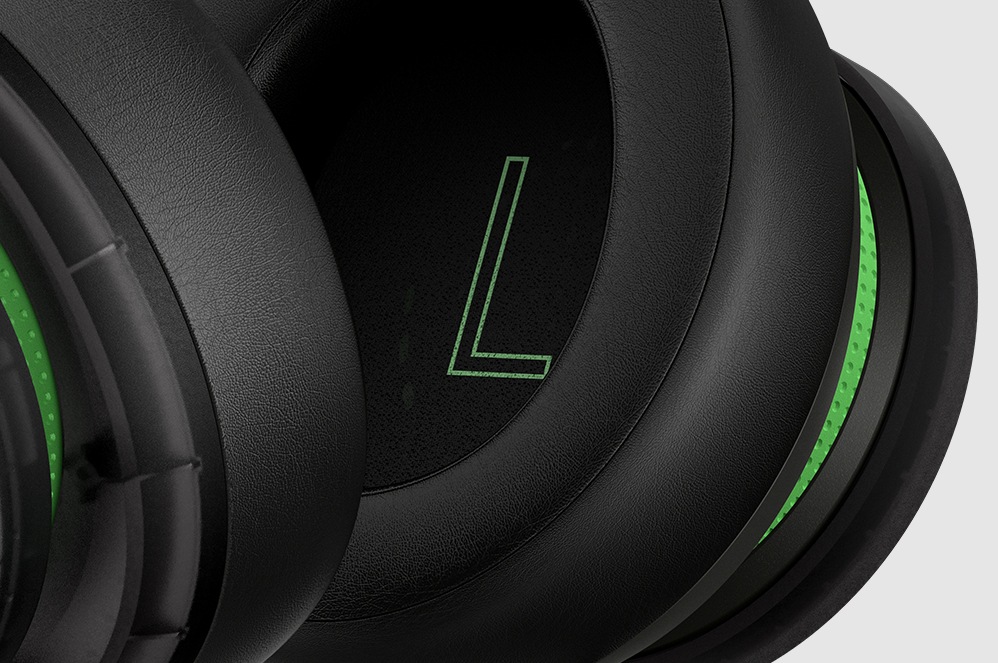 Zbliżenie głośnika lewego nausznika stereofonicznego zestawu słuchawkowego do konsoli Xbox w specjalnej wersji z okazji 20-lecia