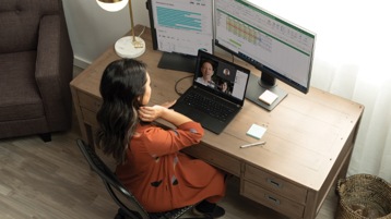 Henkilö työpöydän ääressä osallistumassa Teams-videopuheluun.