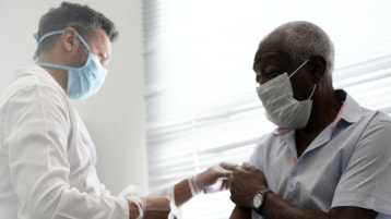 En sundhedsmedarbejder administrerer en vaccine til en patient.