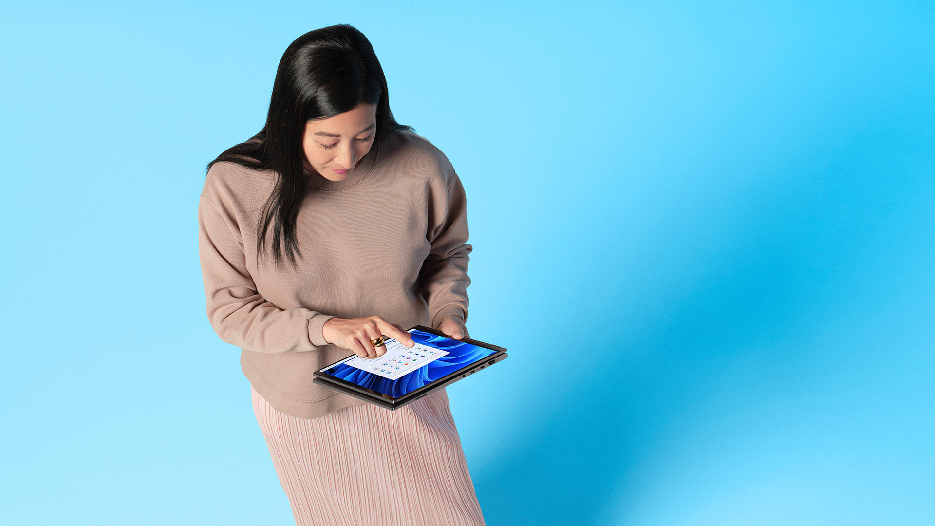 A woman using a touchscreen device that has Windows 11 installed
