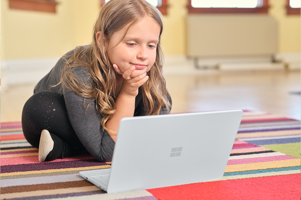 教室の机で Surface Laptop SE を使用する子ども。