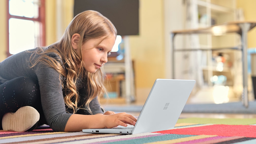Surface Laptop SE を持つ子ども。 