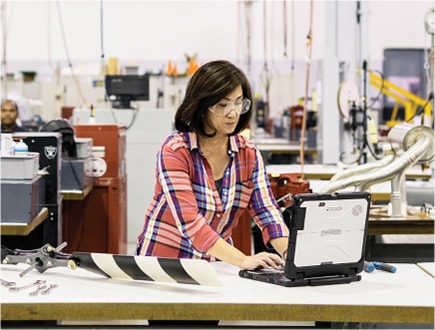 Una persona trabajando en un portátil en una fábrica.