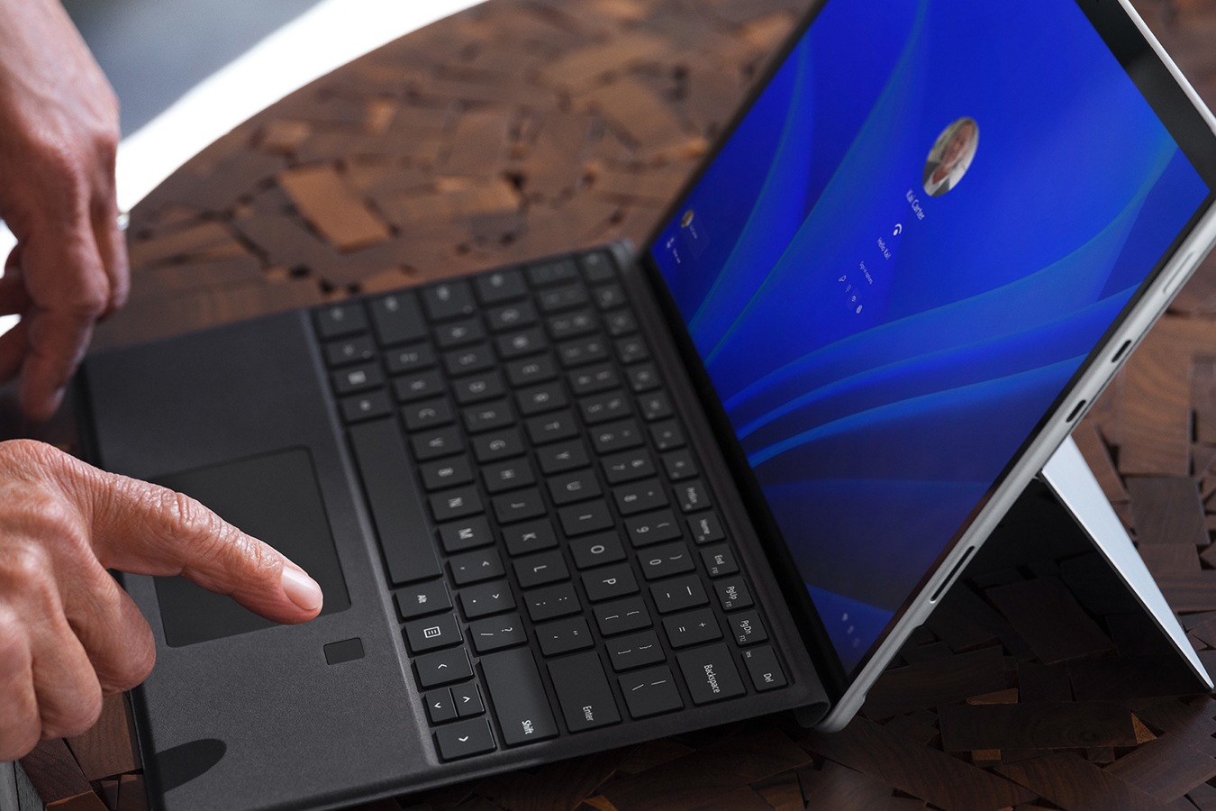 Fingeren til en person holdes over funksjonen for biometrisk pålogging på Surface Pro Signature Keyboard