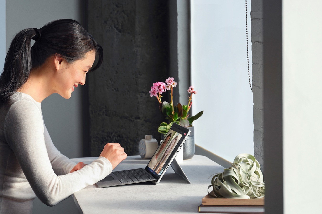 A person is observed taking a Microsoft Teams call from a Surface Pro 8 device in a remote work setting