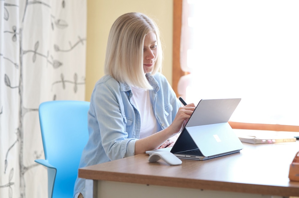 Eine Lehrkraft verwendet einen Surface Slim Pen 2, um auf ihrem Surface Laptop Studio zu schreiben